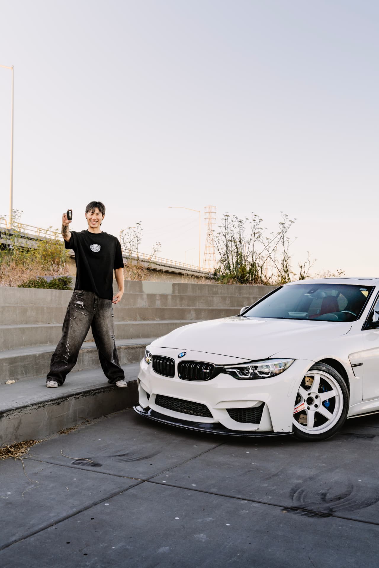 Owner raising the M3 key beside the car