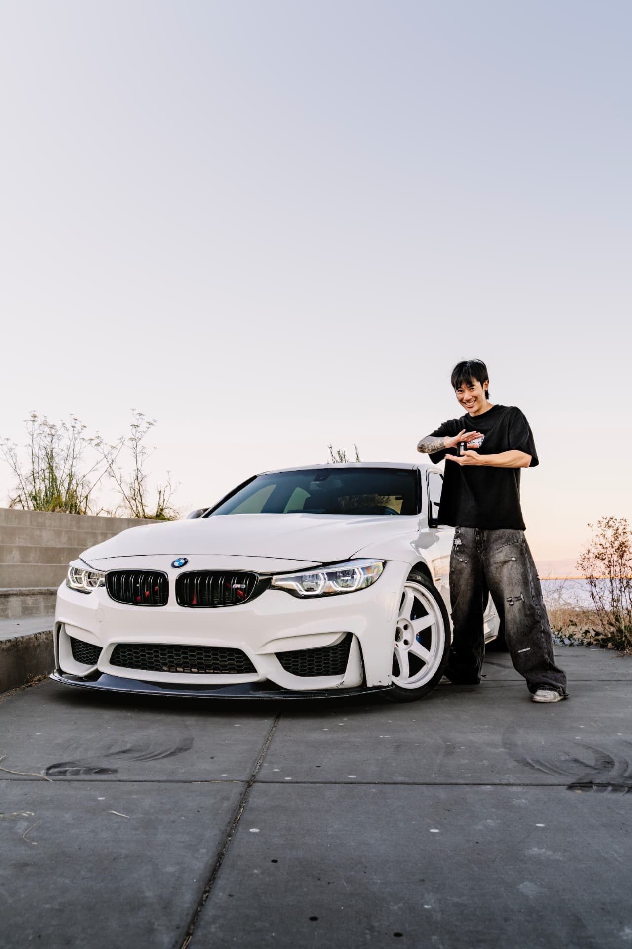 Owner holding the key in front of the BMW M3 F80 at dusk